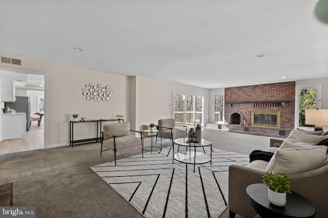 living room featuring recessed lighting, a brick fireplace, visible vents, and light carpet