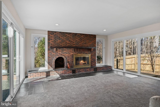 unfurnished living room with carpet, a fireplace, and recessed lighting