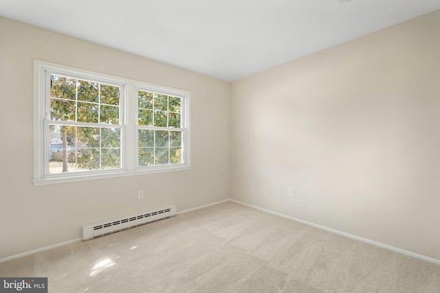 carpeted empty room featuring a baseboard heating unit and baseboards