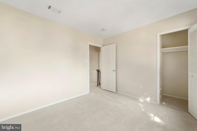 unfurnished bedroom featuring a closet, carpet, visible vents, and baseboards