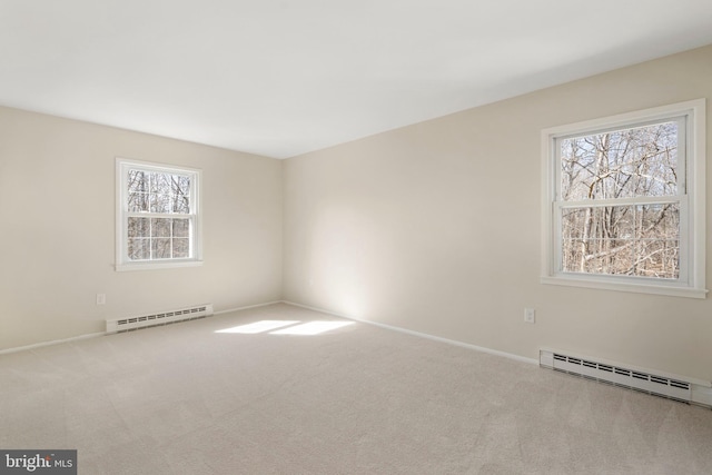 spare room with a baseboard radiator, carpet flooring, and baseboards