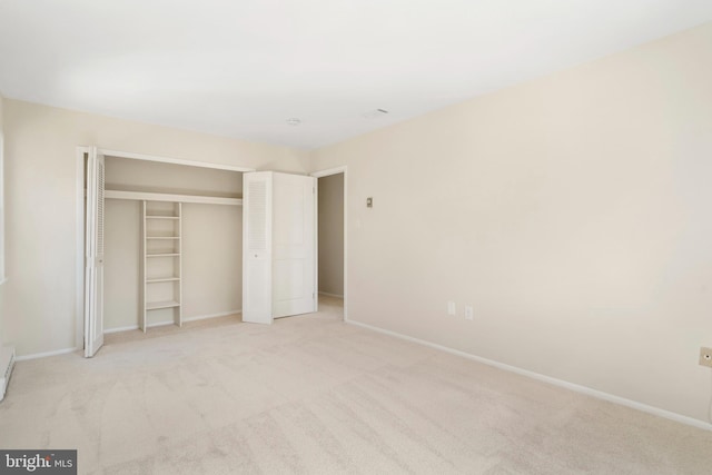 unfurnished bedroom featuring carpet floors, baseboards, and a closet