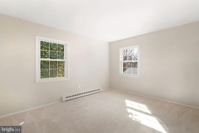 carpeted empty room featuring a baseboard heating unit