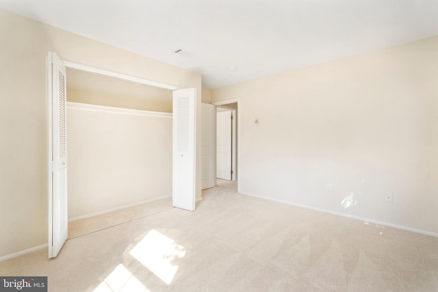 unfurnished bedroom with carpet, a closet, and baseboards