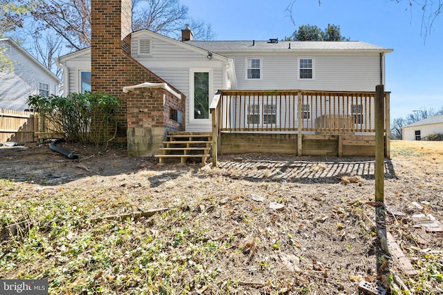 back of house with a chimney, fence, and a deck