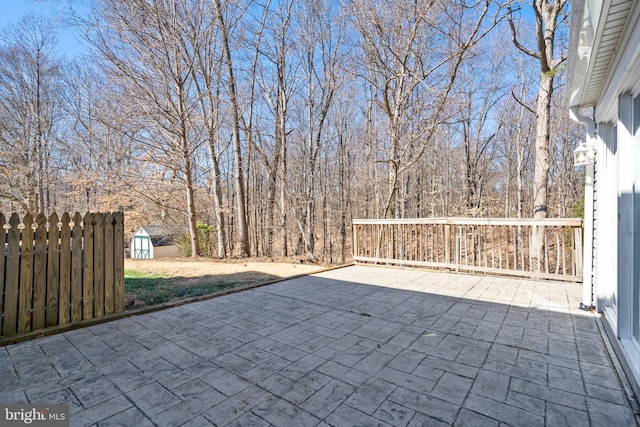 view of patio / terrace with a storage shed, an outdoor structure, and fence