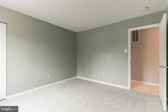 empty room featuring light carpet, baseboards, and visible vents