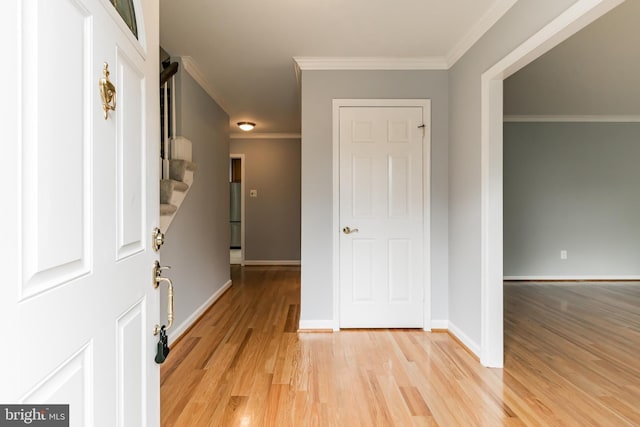 foyer with baseboards, stairs, light wood-style flooring, and crown molding