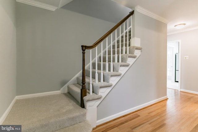 stairs featuring baseboards, wood finished floors, and crown molding