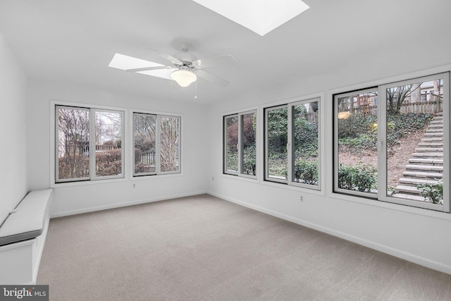 unfurnished sunroom with a skylight and ceiling fan