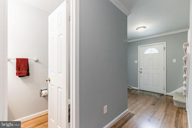 entryway with baseboards, wood finished floors, and crown molding