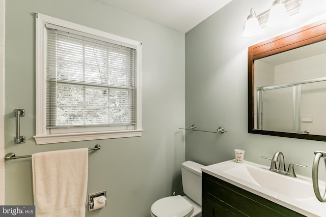 bathroom featuring vanity, an enclosed shower, and toilet