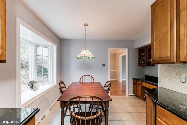 dining area with light tile patterned floors, visible vents, and baseboards