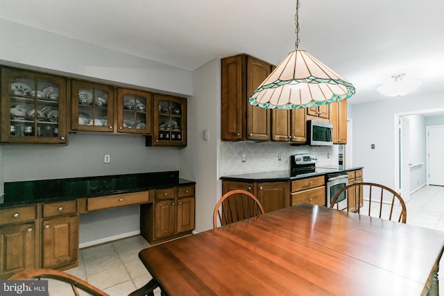 dining space with built in desk, light tile patterned flooring, and baseboards