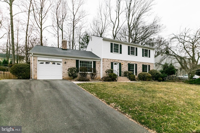 view of front of property featuring brick siding, a chimney, a garage, driveway, and a front lawn