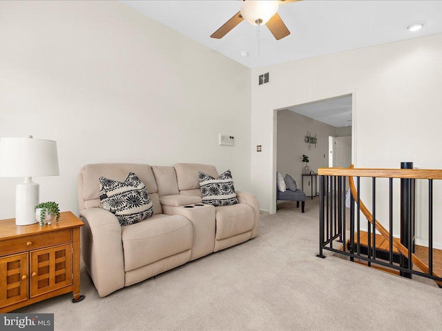 living area with visible vents, light colored carpet, a ceiling fan, and vaulted ceiling