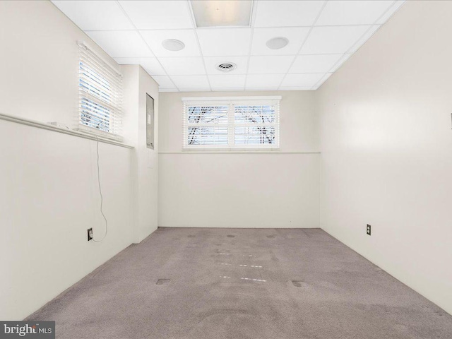 unfurnished room with a drop ceiling, a healthy amount of sunlight, visible vents, and carpet floors