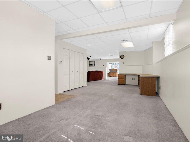 interior space featuring light colored carpet and a paneled ceiling