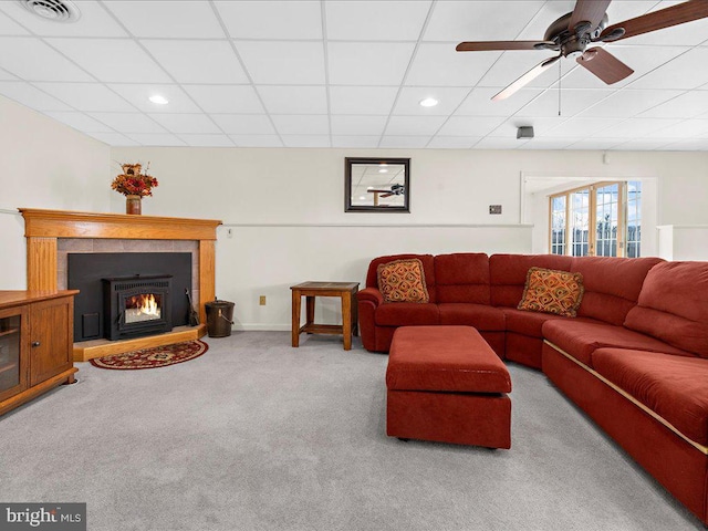 carpeted living area featuring ceiling fan, a paneled ceiling, visible vents, and baseboards