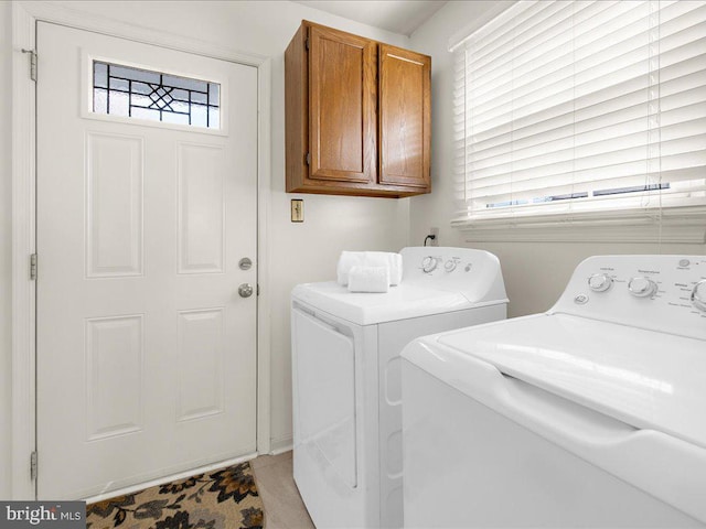 washroom featuring plenty of natural light, cabinet space, and separate washer and dryer