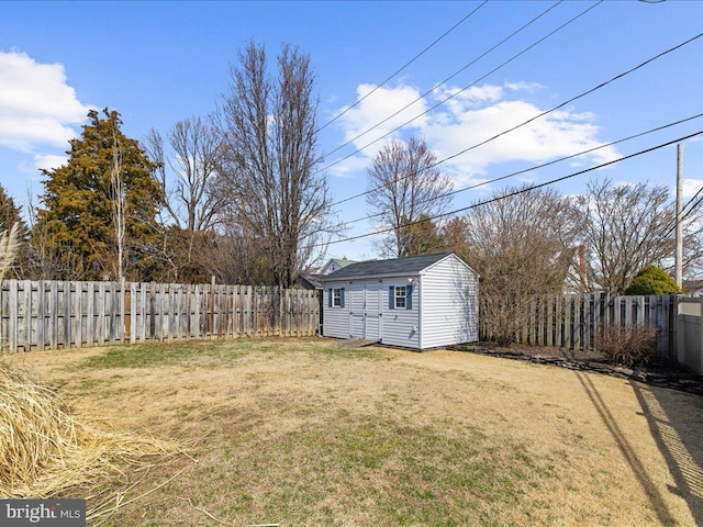 view of yard featuring an outbuilding, a storage unit, and a fenced backyard