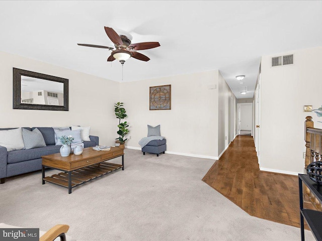 living room with visible vents, attic access, carpet, and baseboards