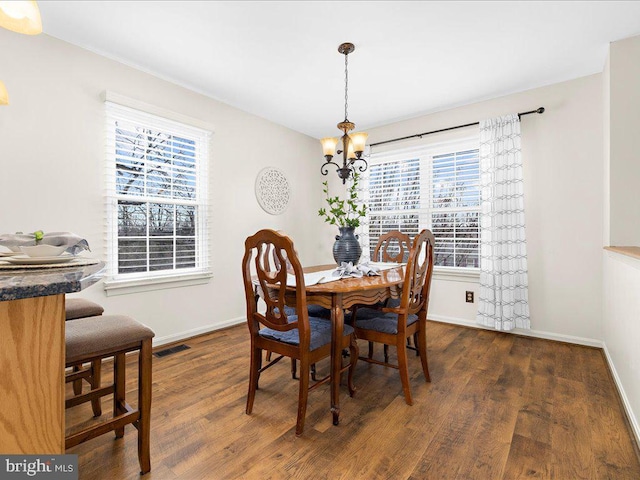 dining area featuring visible vents, baseboards, and wood finished floors