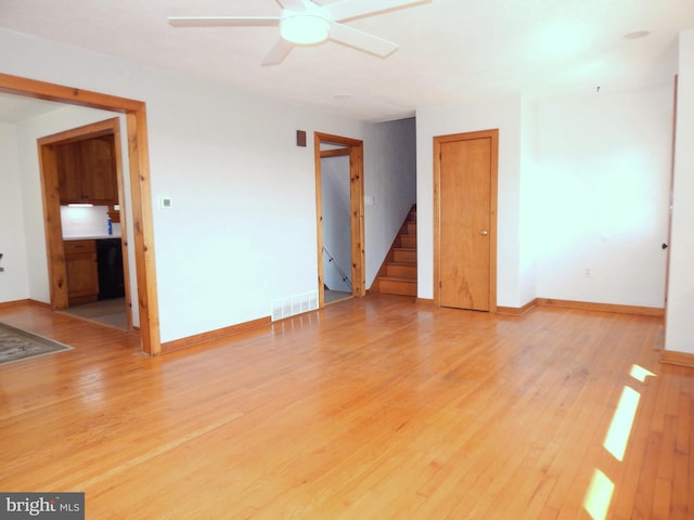 interior space with light wood-style flooring, stairway, visible vents, and baseboards