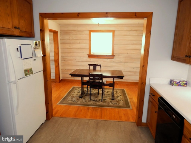 dining space featuring wood walls and light wood-type flooring