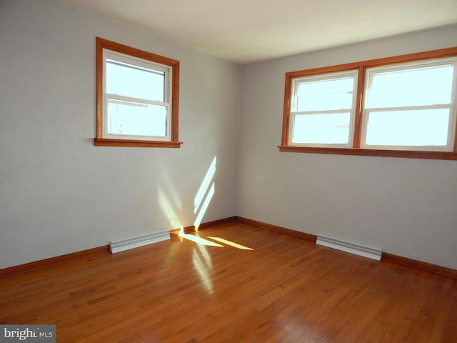 unfurnished room with light wood-style floors, visible vents, and a healthy amount of sunlight