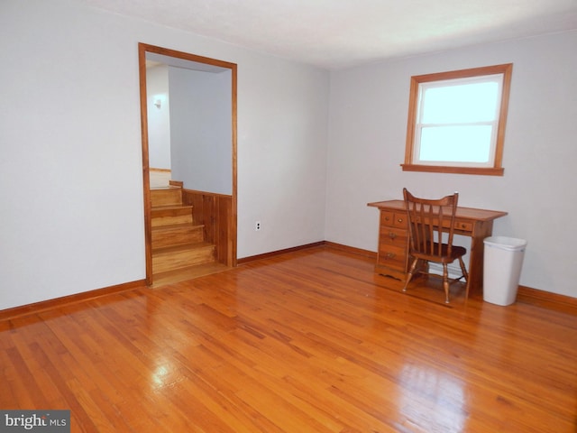 unfurnished office featuring light wood-type flooring and baseboards