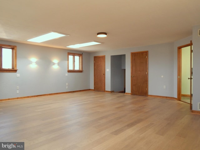 spare room featuring light wood-style floors and baseboards