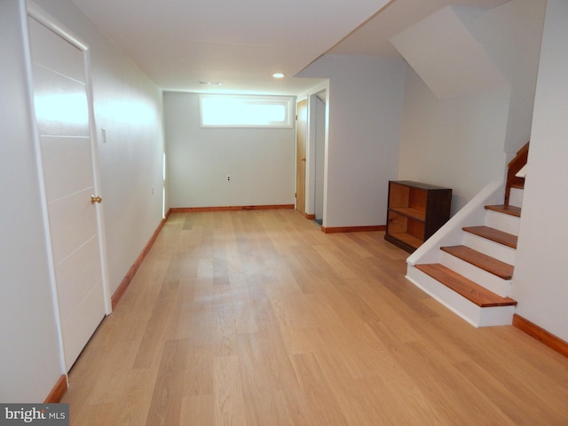 below grade area featuring light wood-style flooring, stairs, baseboards, and recessed lighting