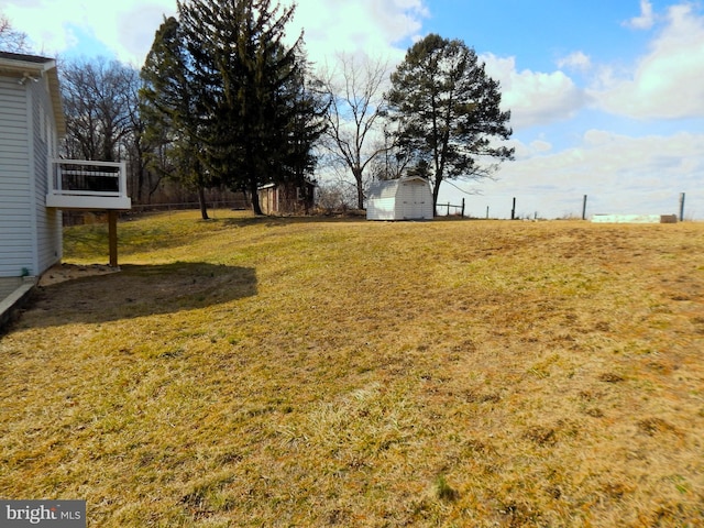 view of yard with fence and an outdoor structure