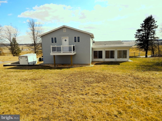 back of property with a lawn and a sunroom