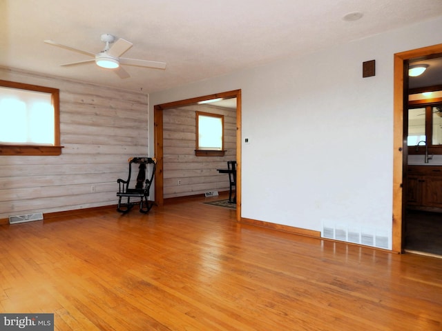 spare room featuring light wood-type flooring, visible vents, and a sink