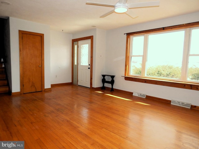 interior space with light wood-type flooring, visible vents, ceiling fan, and baseboards