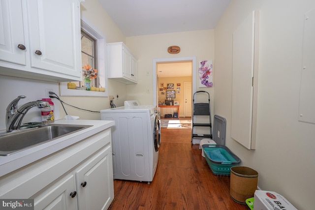 washroom featuring dark wood-style floors, independent washer and dryer, cabinet space, and a sink