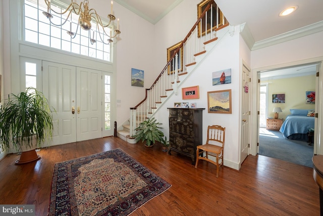 entryway featuring a healthy amount of sunlight, ornamental molding, and wood finished floors