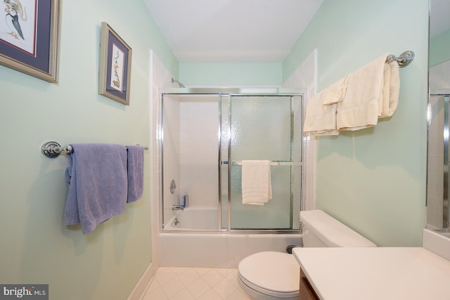 bathroom with toilet, shower / bath combination with glass door, vanity, baseboards, and tile patterned floors