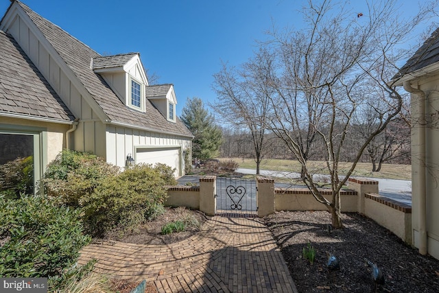 view of patio / terrace with a garage, a gate, and a fenced front yard