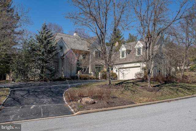 cape cod-style house with driveway and an attached garage