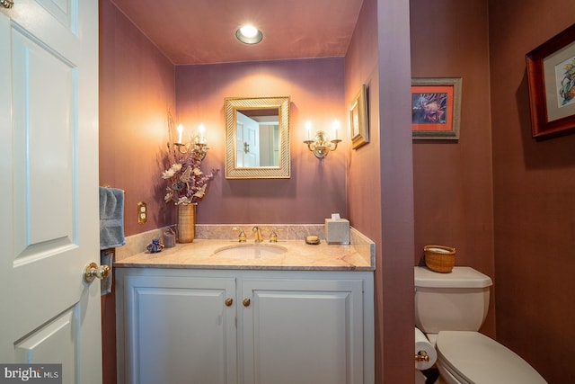 half bathroom featuring toilet, recessed lighting, and vanity