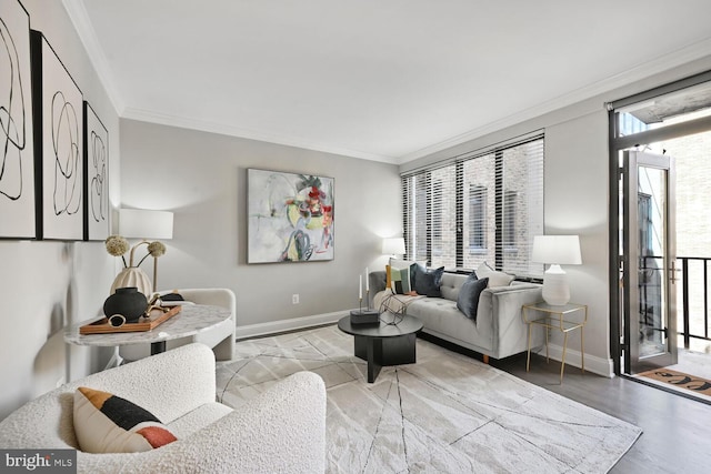 living room featuring crown molding, baseboards, and wood finished floors