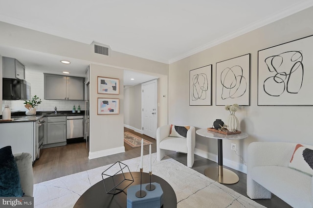 living area with visible vents, ornamental molding, dark wood finished floors, and baseboards