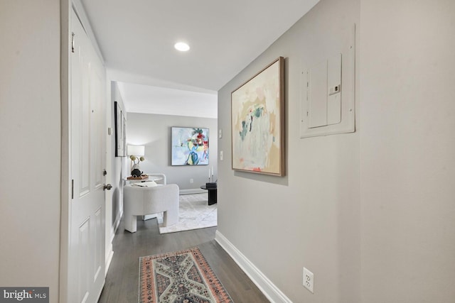 hall with recessed lighting, electric panel, baseboards, and wood finished floors