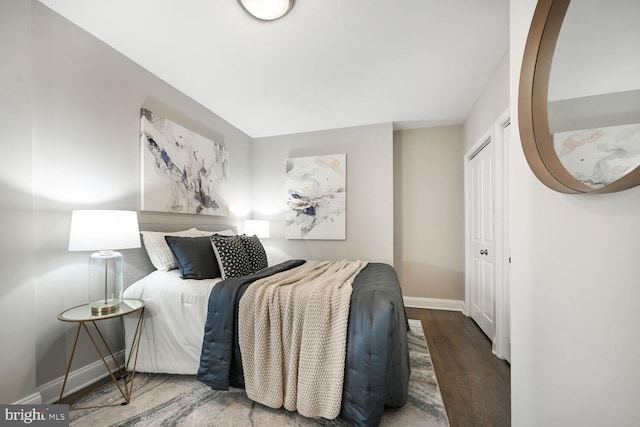 bedroom with a closet, baseboards, and wood finished floors