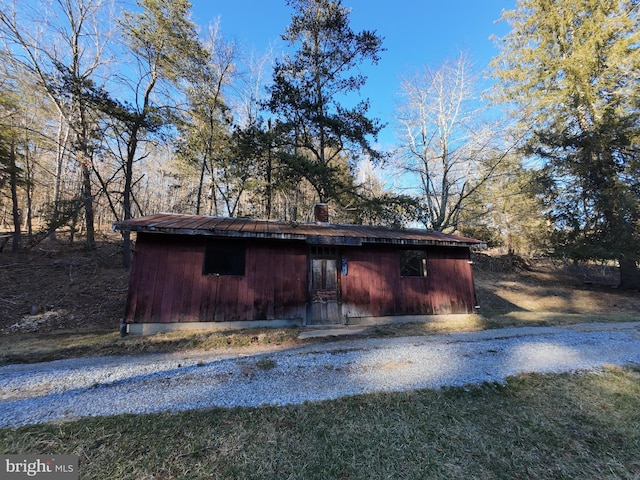 view of property exterior with an outdoor structure and a chimney