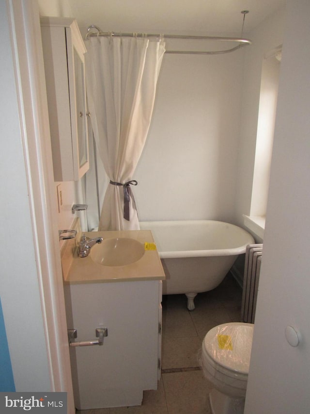 bathroom featuring a soaking tub, radiator, toilet, vanity, and tile patterned flooring