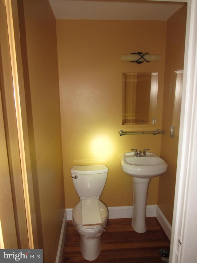 bathroom featuring baseboards, toilet, and wood finished floors